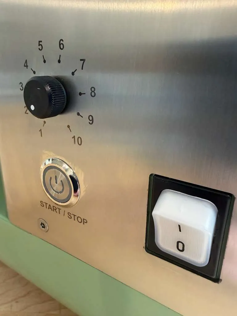 The speed dial numbered 1 to 10, the start/stop button and the power switch on the steel panel.